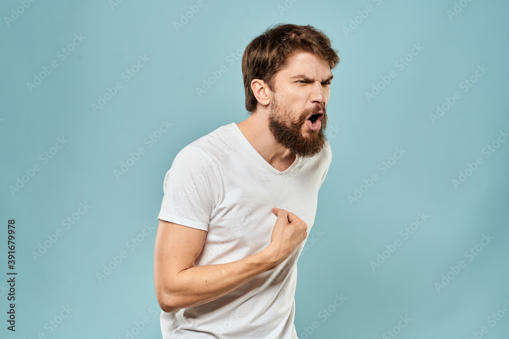 Man gestures with his hands emotions displeasure white t-shirt blue background Man gestures with his hands emotions displeasure white t-shirt blue background