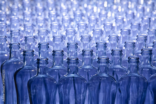 Select focus and close up of an arrangement of empty glass bottles. Glass and abstract concept.