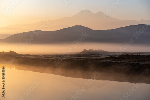 Sunrise with the mist over the river and the plain in Kayseri, in front of Erciyes mountain © attraction art