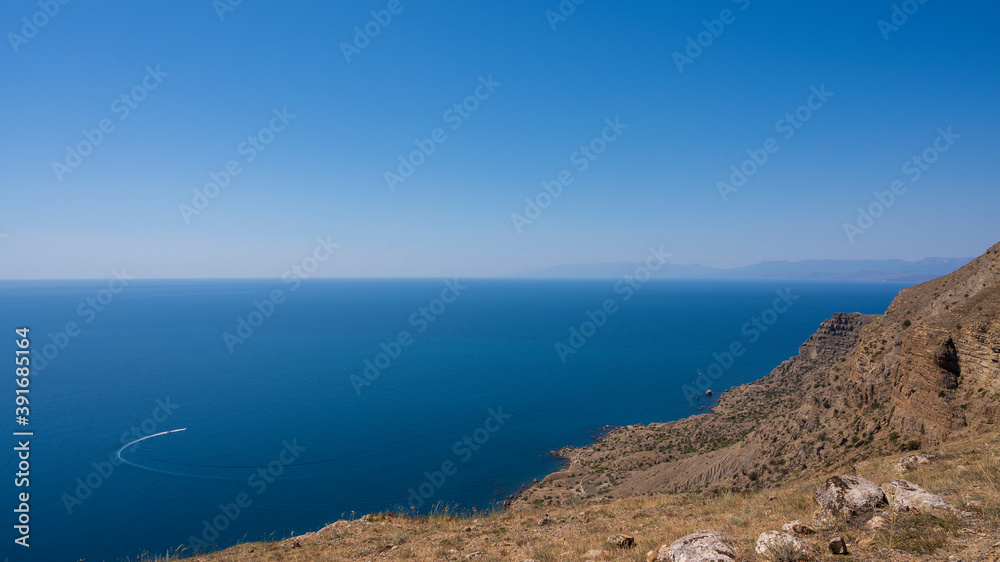 the yacht sails along the rocky coast on the sea the yacht sails along the rocky coast on the sea
