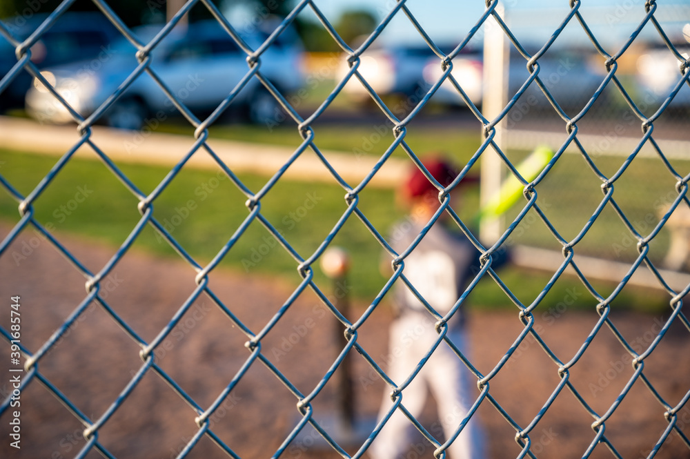 Fototapeta premium selective focus on chain link fence behind tee ball batter