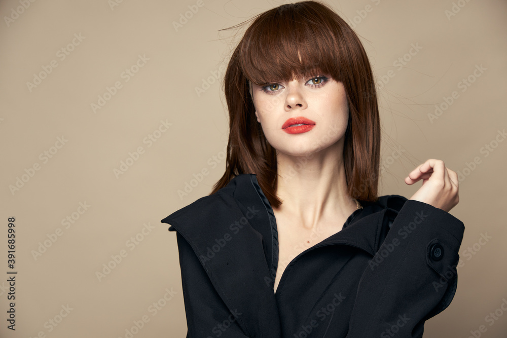 Beautiful woman stylish clothes attractive appearance laughing on a beige background Beautiful woman stylish clothes attractive appearance laughing on a beige background