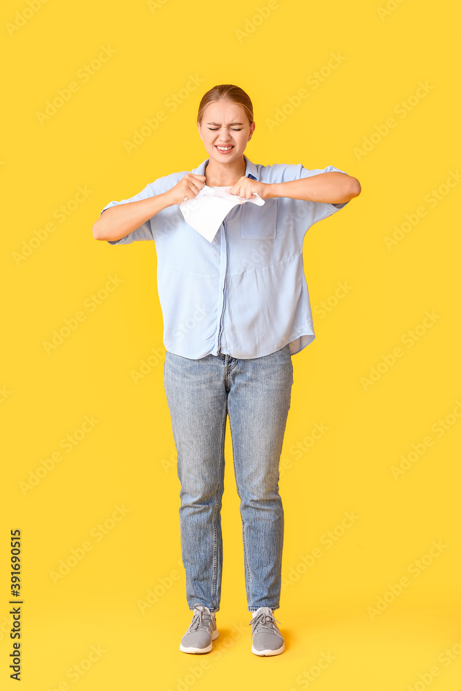 Stressed young woman with paper sheet on color background Stressed young woman with paper sheet on color background