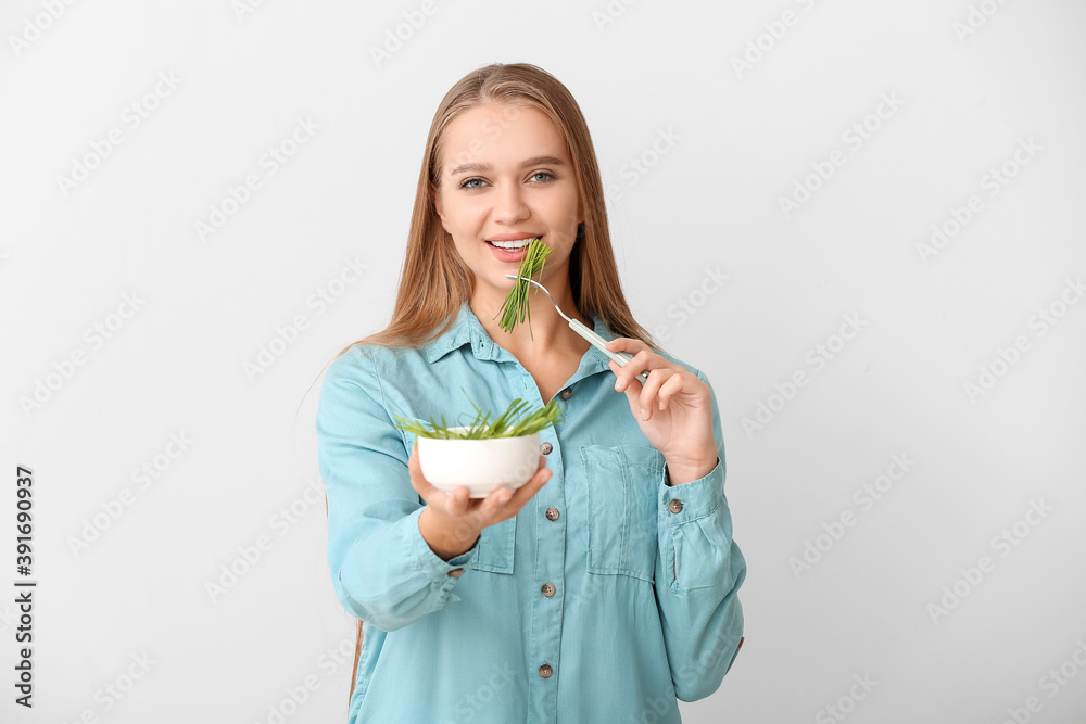 Young woman with wheatgrass on light background Young woman with wheatgrass on light background