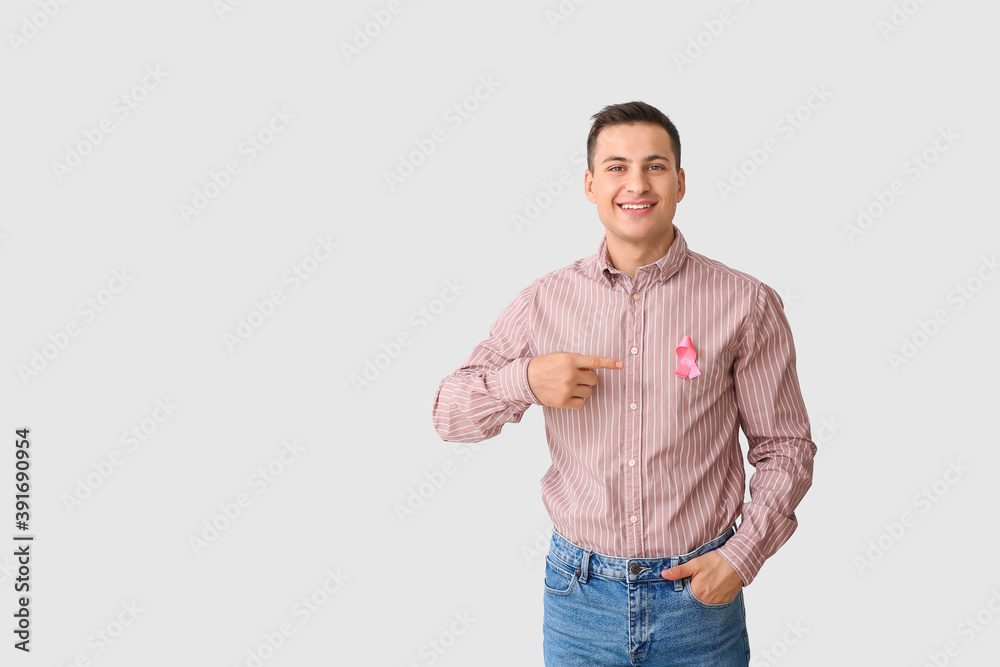 Man with pink ribbon on light background. Breast cancer awareness concept Man with pink ribbon on light background. Breast cancer awareness concept