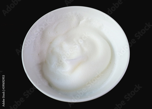Beaten Egg Whites in a Mixing Bowl Isolated on Black Background