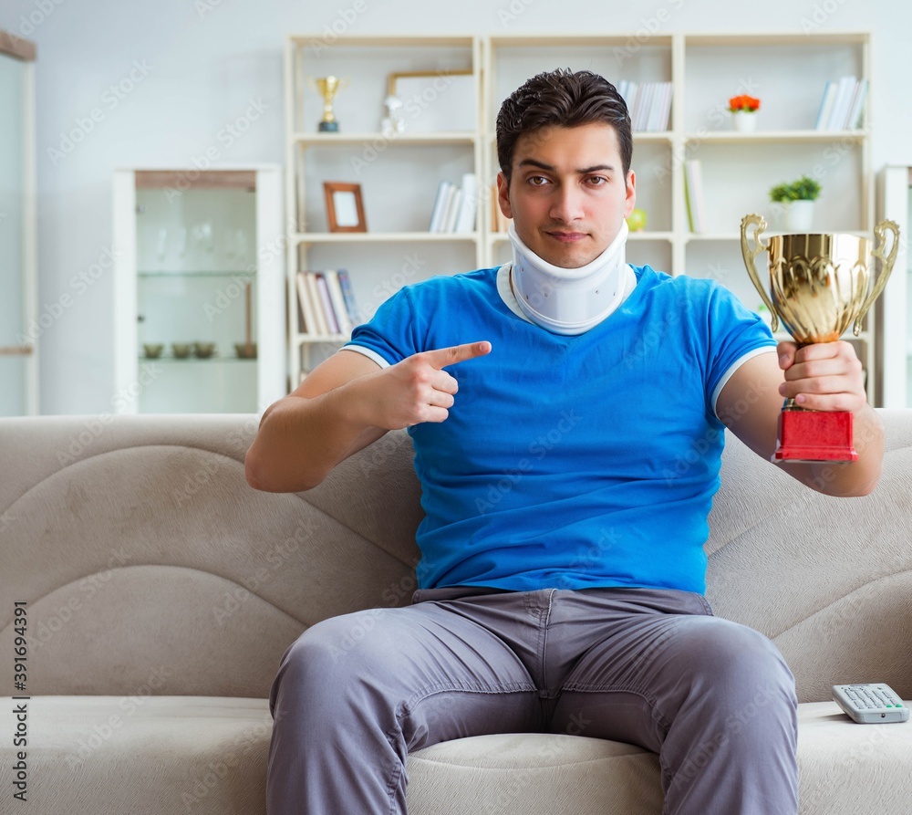 Man with neck injury watching football soccer at home Man with neck injury watching football soccer at home