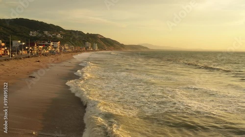 Aerial evening sunset drone shot of coastline town. Evening scenery over Townsvillle from Crucita, Ecuador. Sunset Aerial view. photo