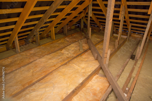 Insulation of the ceiling with fiberglass. Roof insulation. Laying and insulation with stone wool and fiberglass insulation material for a barrier against cold. The concept of building a warm house.