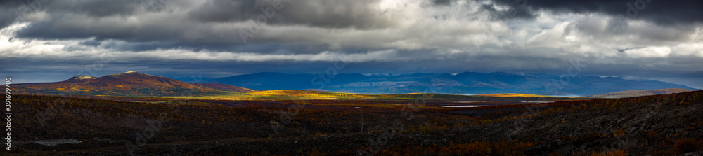 Stormy weather over the Khibiny mountains. First snow on the top of the cliffs. Panoramic view.