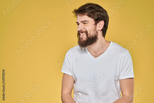 Bearded man on emotions white t-shirt fun lifestyle yellow background