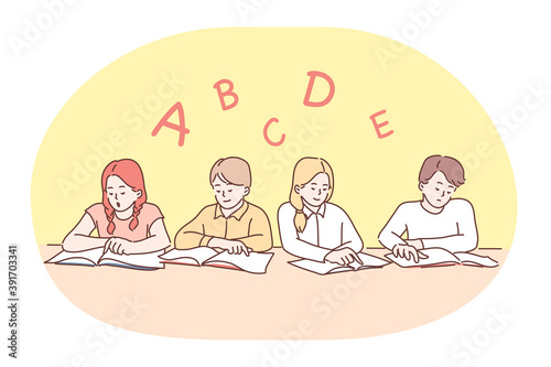 School, lesson, learning letters and alphabet, education concept. Group of positive concentrated children classmates sitting with books and learning letters of english alphabet in classroom 