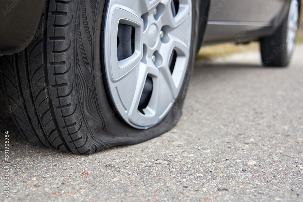 Flat tire of a car, trouble on the road.