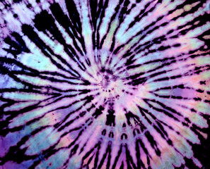 Spiral tie-dye pattern. Hippie tie dye wallpaper. Tiedye background in rainbow pastel violet, purple, pink.