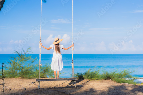 Portrait beautiful young asian woman relax smile on swing around beach sea ocean
