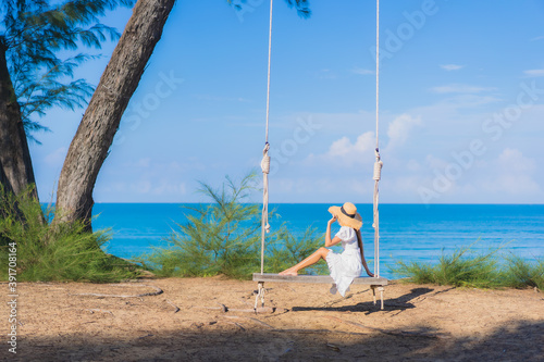 Portrait beautiful young asian woman relax smile on swing around beach sea ocean © siraphol