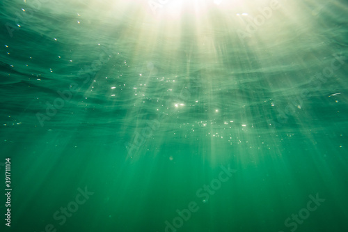 Ocean surface of the baltic sea with beautiful sun rays photographed from underwater