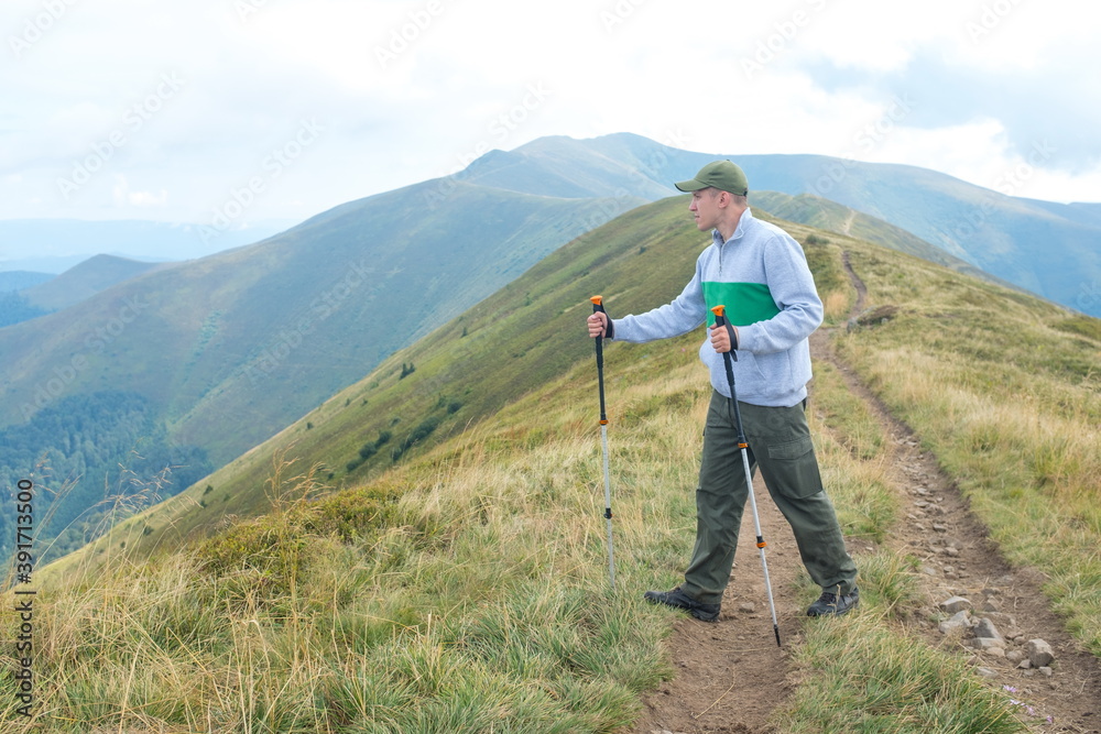 Hiker Man in a summer mountains. Trekking and outdoor concept. 