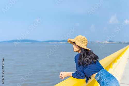 portrait woman stand on the yellow bridge with sea landscape and  mountain  relax and calm in sunny day concept vacation, relaxing, positive thinking, enjoy, alone, lonely
