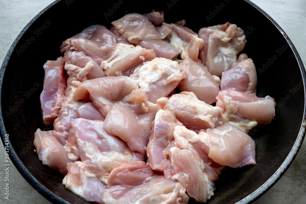 Pieces of fresh chicken meat in a frying pan Pieces of fresh chicken meat in a frying pan