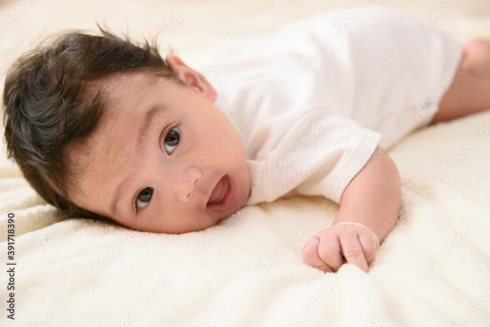 A cute little Asian baby lies on the stomach with copy space A cute little Asian baby lies on the stomach with copy space