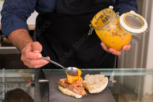 male hands of a chef make meat sandwiches with beef and sandwich and empanadas, traditional tasty latin food, with meet or vegetarian in a fancy bakery in Lisbon . Process of making sandwiches