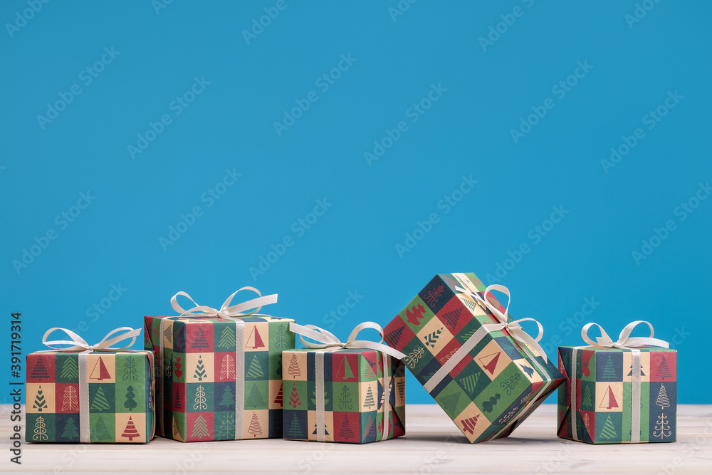 Gifts in boxes, wrapped in paper with Christmas and New Years drawings. Copy space, blue background.