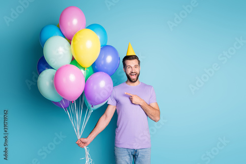 Canvas Print Photo portrait of cheerful happy man pointing at balloons in festive cone celebr