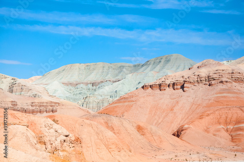 Scenic landscape of beautiful, pink color sandstone Aktau Mountains in Altyn Emel National Park on a sunny hot day, Kazakhstan