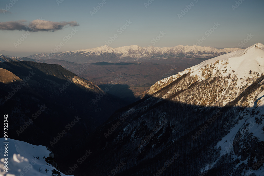 Mountains peak with snow with blue cloudy sky. Fantastic winter landscape.  Beautiful world.