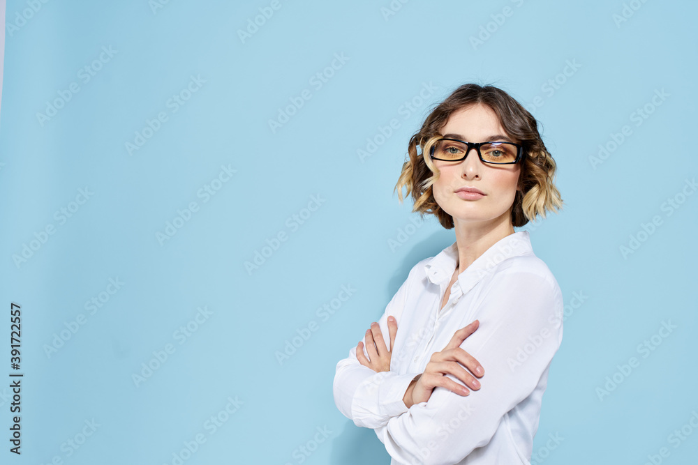 Business woman on a blue background glasses with dark rims curly hair Light shirt cropped view Business woman on a blue background glasses with dark rims curly hair Light shirt cropped view