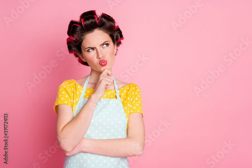 Portrait of pensive girl look copyspace think wear retro clothes hair curlers isolated on pastel color background © deagreez
