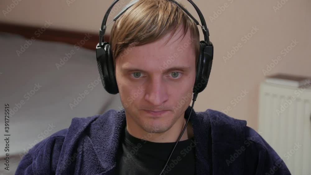 Stressful man playing video games closeup in headphones at home