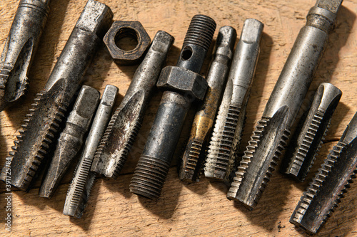 Old vintage hand tools - drills and threading die on a wooden background