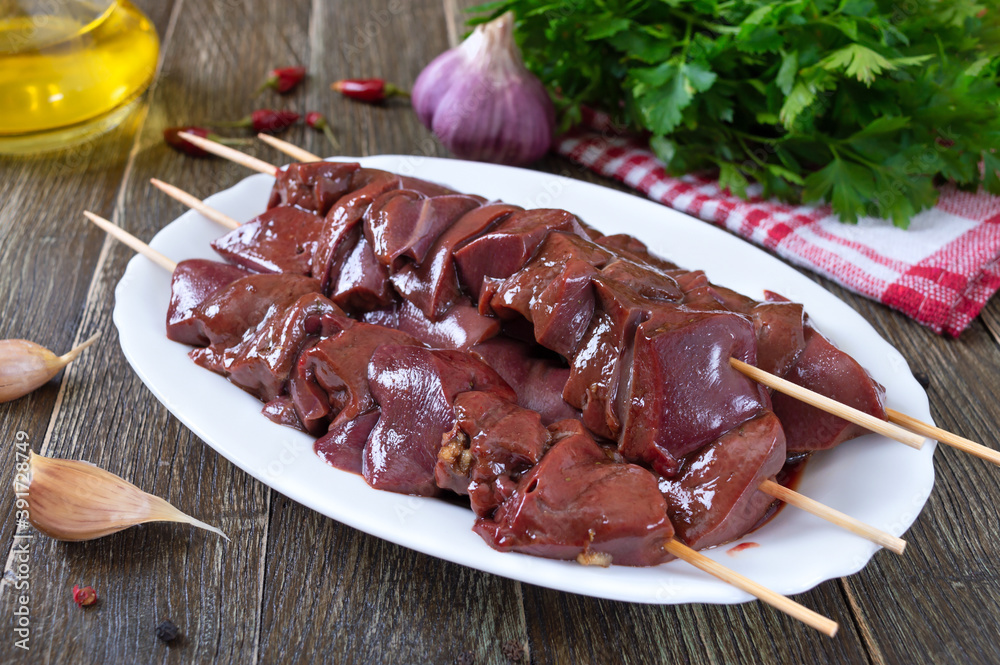 Pieces of raw pork liver on wooden skewers for cooking barbecue. Diet dish. Asian cuisine.