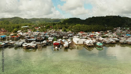 Fishing village with boats and slums with wooden houses, aerial drone. Dapa, Siargao, Philippines. photo