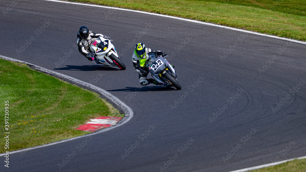 A shot of two racing bikes cornering on a track.