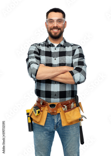 profession, construction and building - happy smiling male worker or builder in goggles with crossed arms over white background © Syda Productions