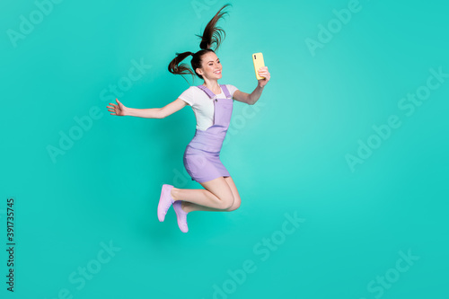 Full length body size side profile photo of funny female blogger texting on smartphone social media isolated on vivid teal color background