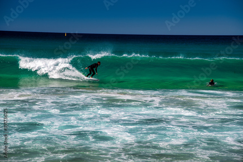 BONDI BEACH, AUSTRALIA - AUGUST 18, 2018: Surfers enjoy the waves on a beautiful morning