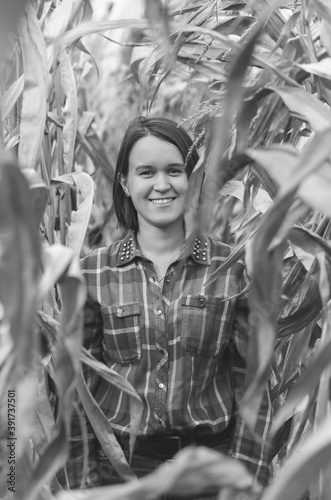 Black and white shot of Woman in the dried corn stalks in a corn maze.