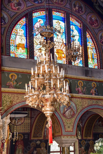 Interior of Orthodox church (side with stained glass window,the candelabrum and Byzantine hagiographies) in Greece photo