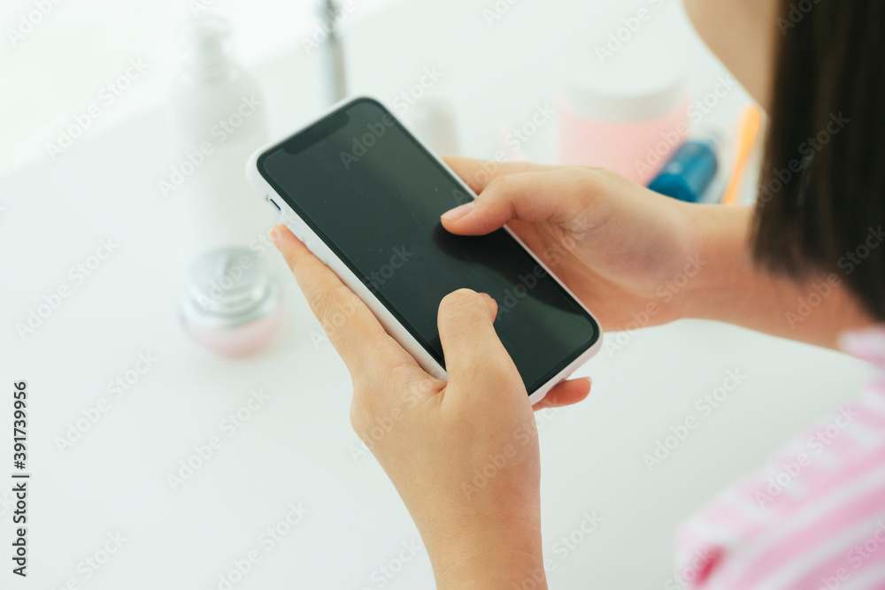 Beautiful young asian thai black short hair woman using smartphone in restroom. Beautiful young asian thai black short hair woman using smartphone in restroom.