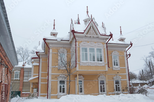 Vintage wooden house with firebirds, carved windows, frames in Tomsk city, Russia. Russian traditional national folk style in architecture. Tomsk landmark, Tomsk monument, sightseeing. Russian winter
