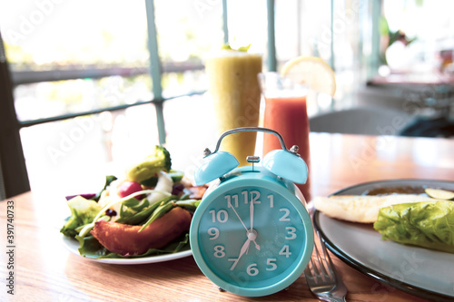 Selective focus with Blue clock breakfast time and Intermittent fasting ,Diet healthy food Lifestyle concept. photo