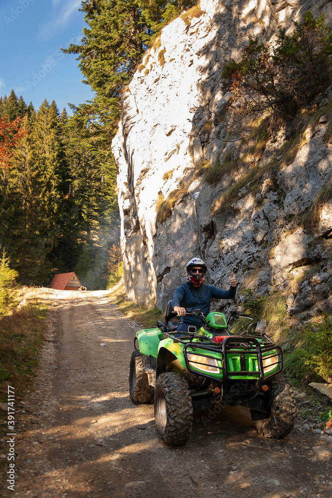 Fototapeta premium A man on a quad bike in the mountains.