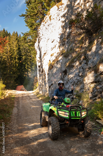 A man on a quad bike in the mountains.