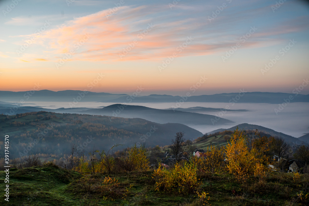 sunrise on a background of mountains in the fog. autumn season.