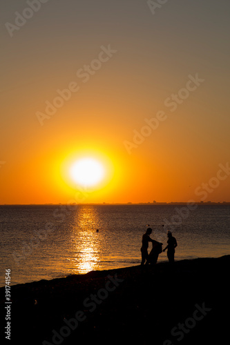 people on the seashore during sunset