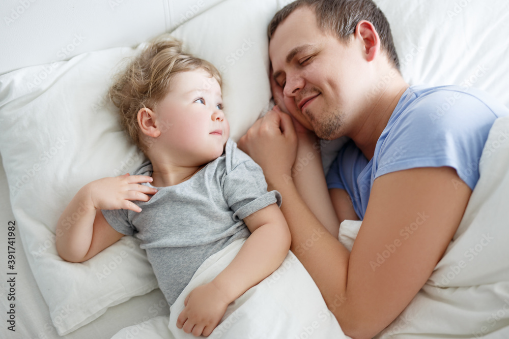 top view of happy father and cute little daughter waking up at home top view of happy father and cute little daughter waking up at home